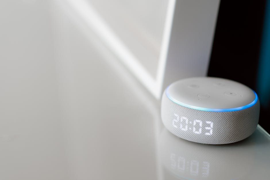 Close-up of a smart speaker with a digital clock display on a minimalist surface.