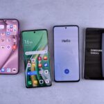 Four modern smartphones showcasing home screens, applications, and startup logos on a sleek surface.