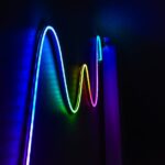 Colorful neon wave pattern LED lights illuminating a dark room for a modern home decor aesthetic.